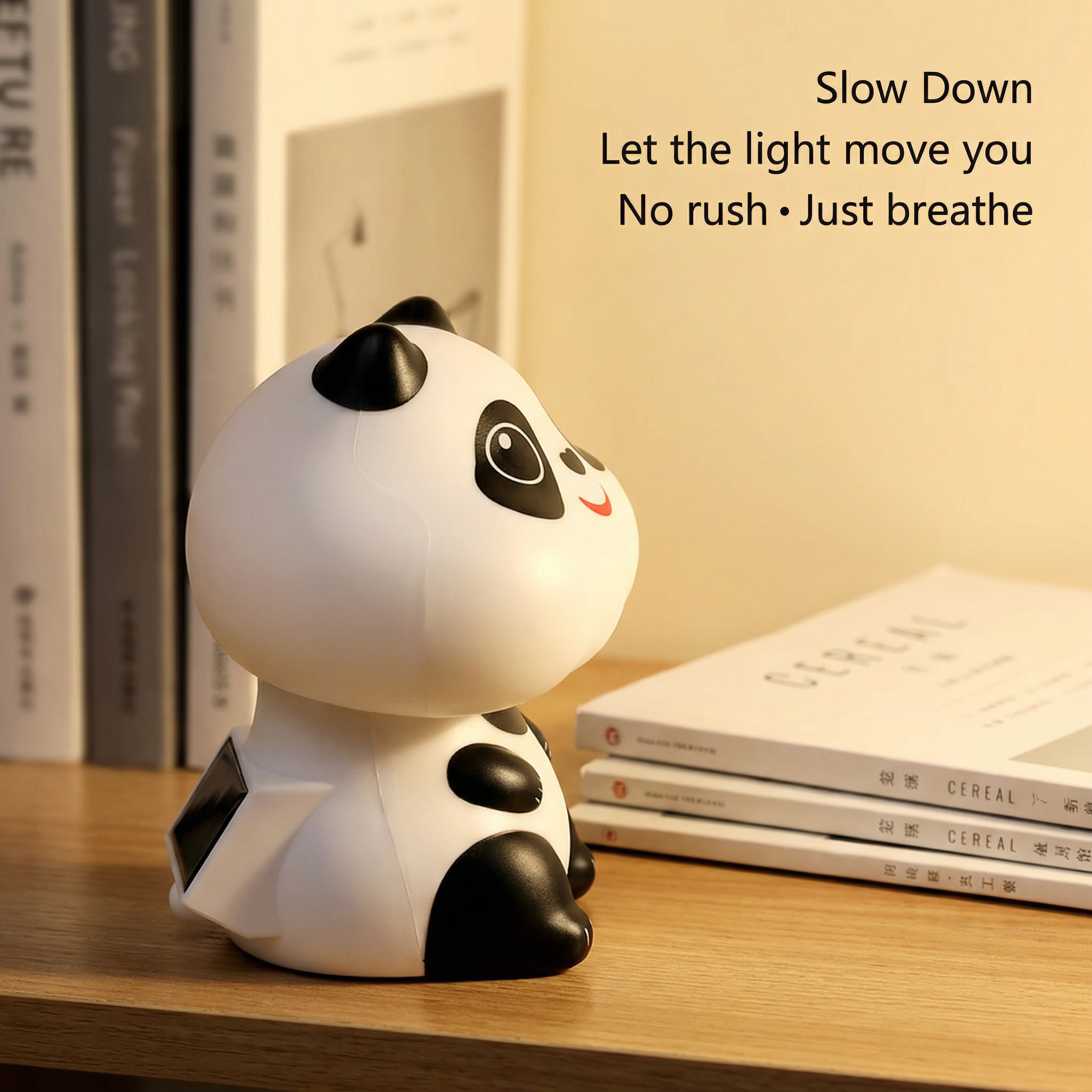 Solar panda figurine on wooden bookshelf next to stacked books in warm ambient lighting