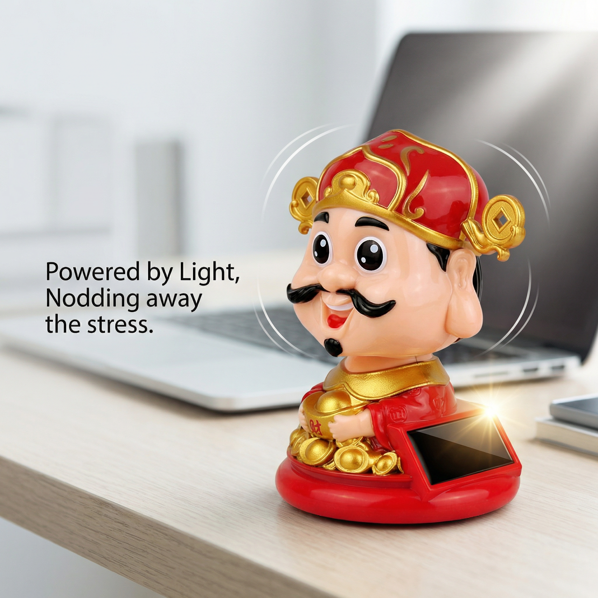 Solar-powered Caishen desk figurine nodding next to laptop in office setting